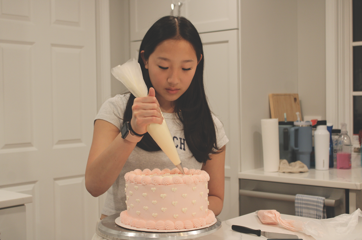 Senior Anna Bozarth frosts a customer’s 18th birthday cake. Bozarth bakes and decorates treats such as cakes and cupcakes for customers that order from her baking business.